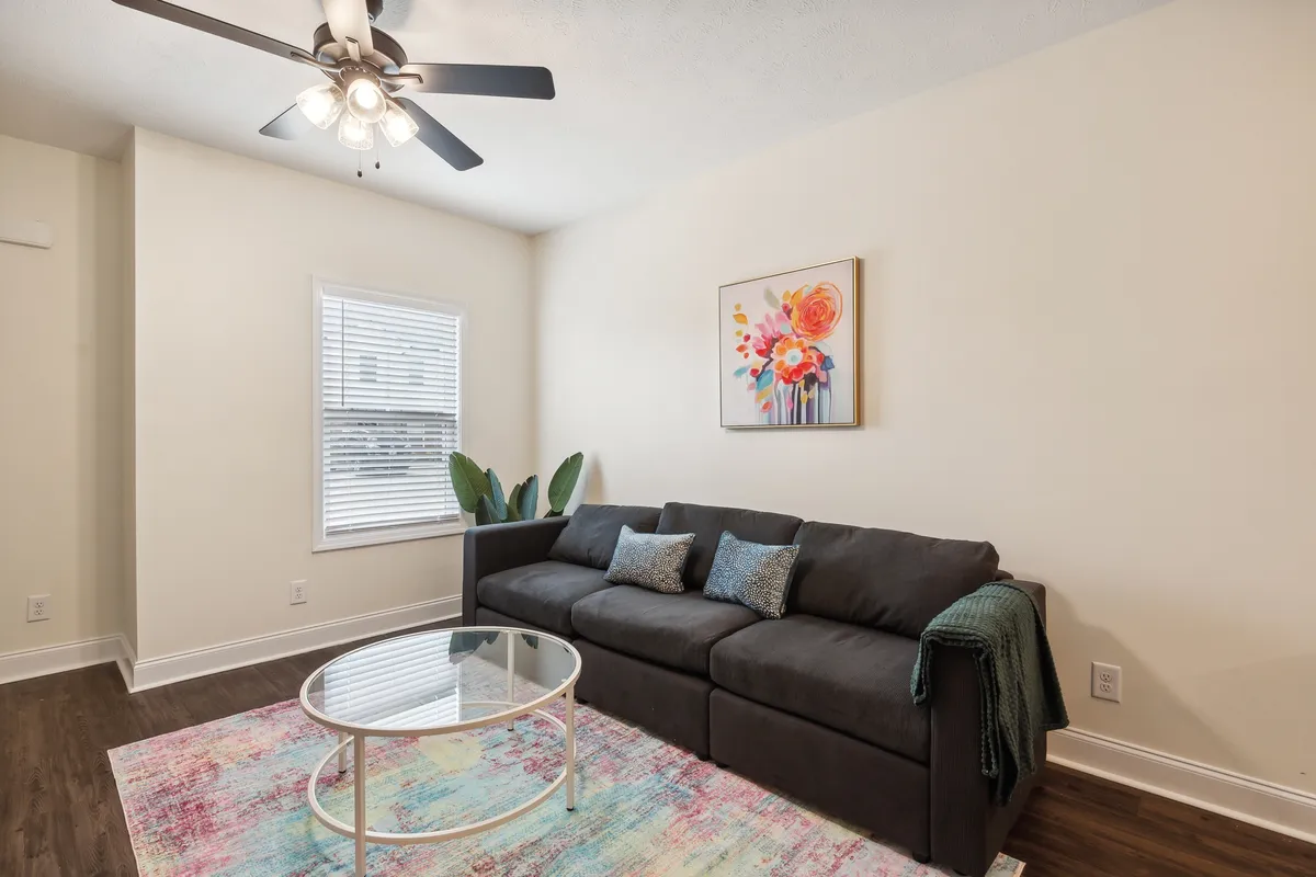 A cheerful living space featuring a cozy sofa, a sleek coffee table, artistic touches, a sunlit window, and fresh plants. The arrangement suggests both relaxation and opportunities for socializing or quiet reading, echoing the section's focus on comfort and ease.